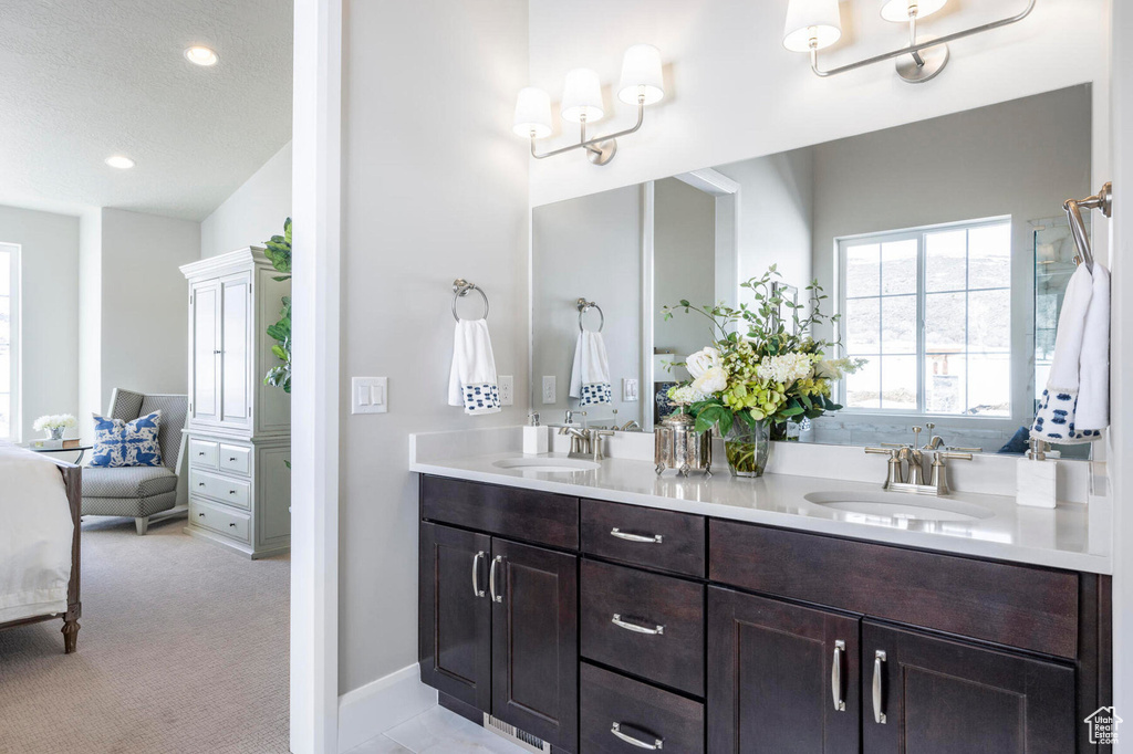 Bathroom with double vanity, connected bathroom, recessed lighting, and baseboards
