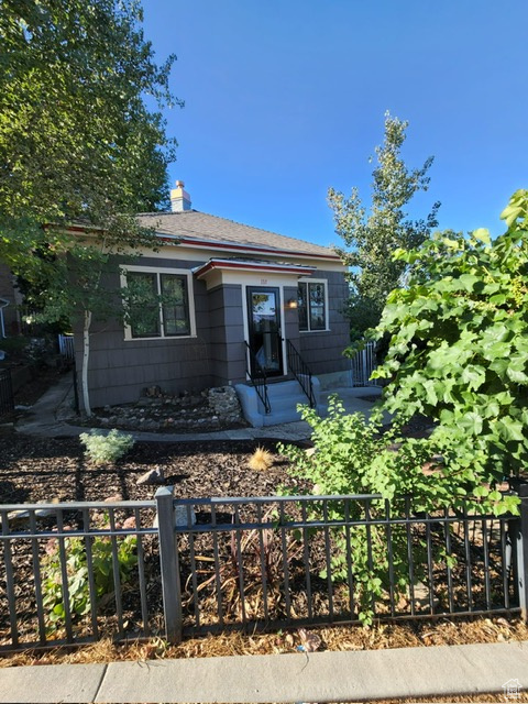 View of front of home with entry steps and a chimney