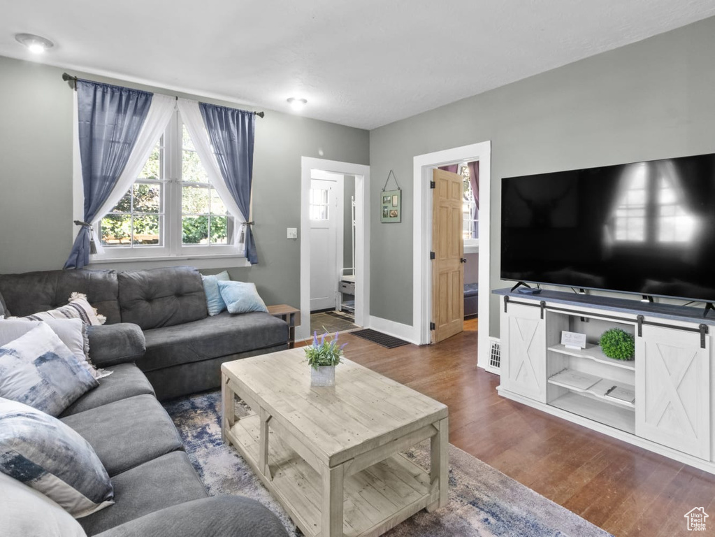 Living area featuring dark wood-type flooring and baseboards