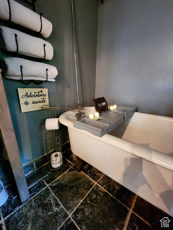 Bathroom featuring a freestanding tub and marble finish floors
