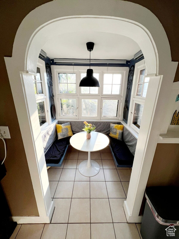 Living area with breakfast area, arched walkways, and light tile patterned floors