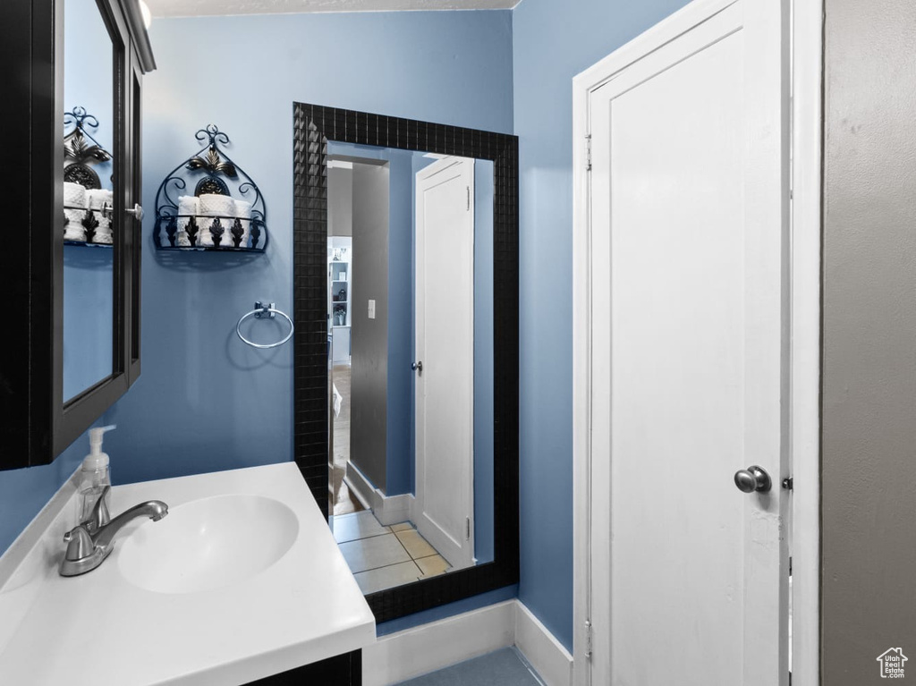 Bathroom featuring vanity, tile patterned flooring, and baseboards