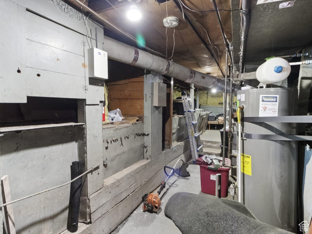 Unfinished below grade area featuring water heater