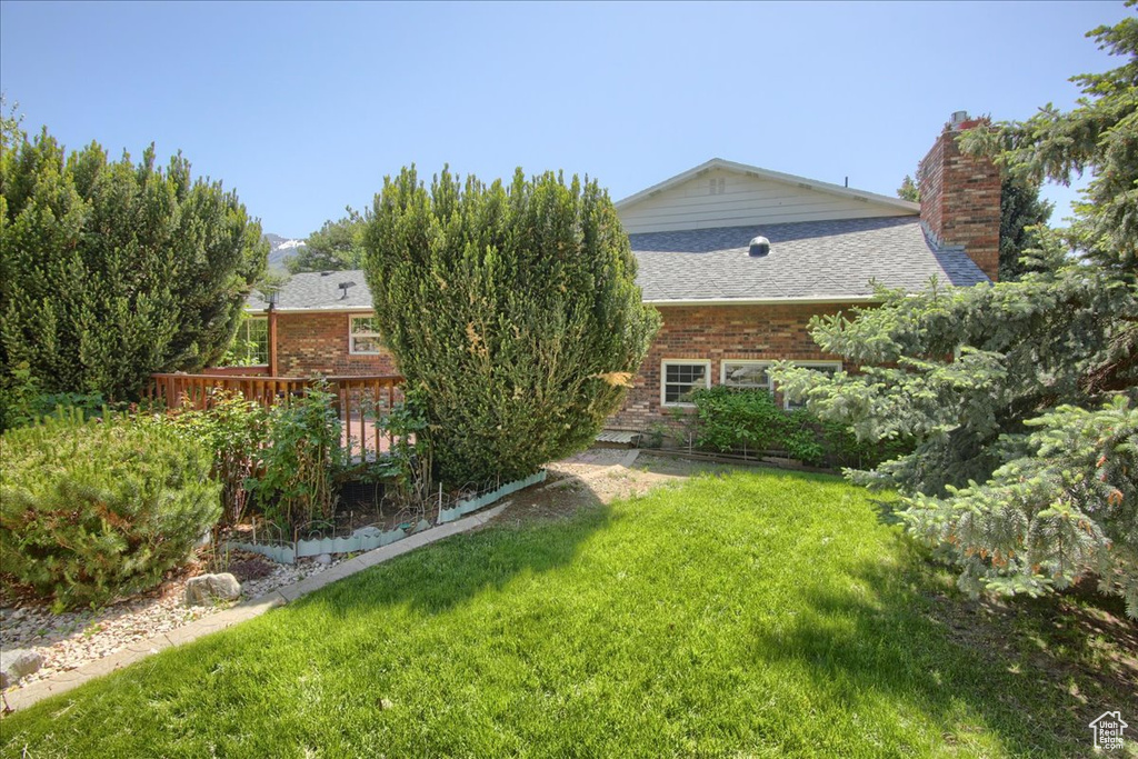 View of green lawn with a wooden deck