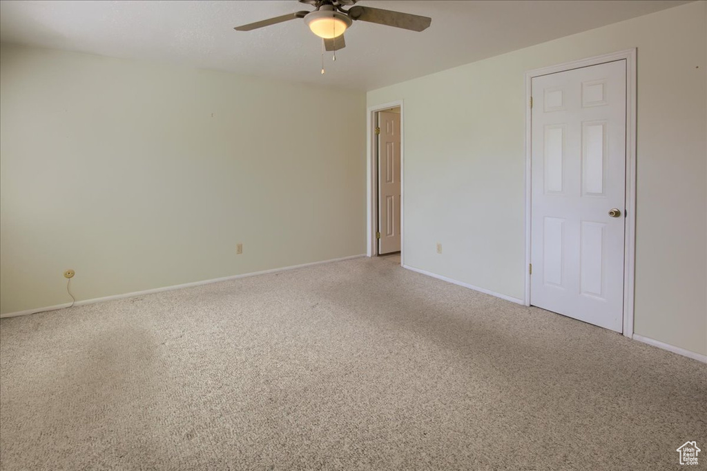 Unfurnished room featuring a ceiling fan, carpet flooring, and baseboards