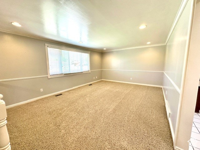 Spare room featuring crown molding, recessed lighting, light colored carpet, and baseboards