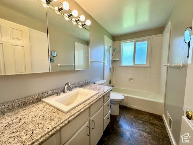 Bathroom with toilet, vanity, and washtub / shower combination