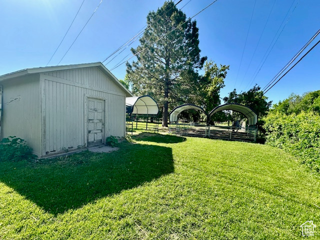 View of green lawn featuring an outbuilding