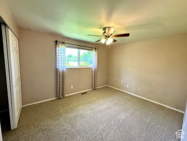 Unfurnished bedroom featuring carpet flooring, baseboards, a ceiling fan, and a closet