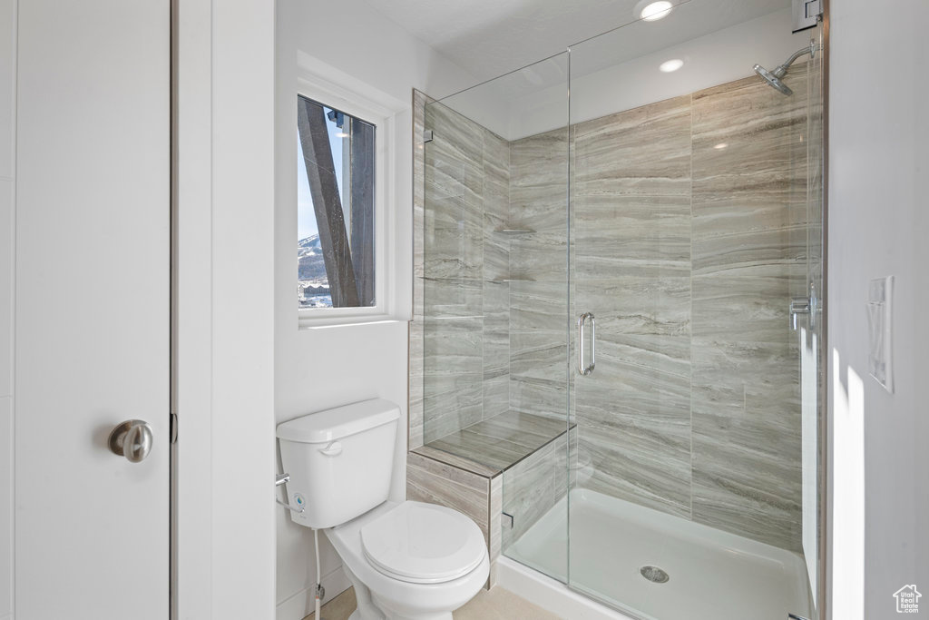 Bathroom featuring a stall shower and toilet