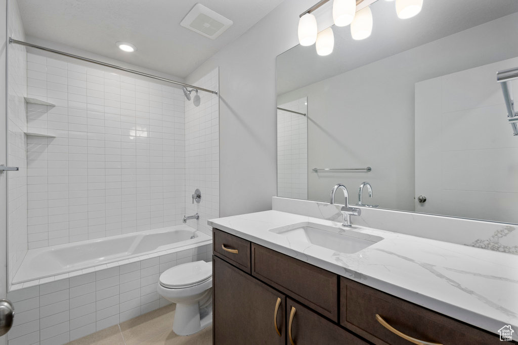 Full bath with toilet, tiled shower / bath, vanity, and tile patterned flooring
