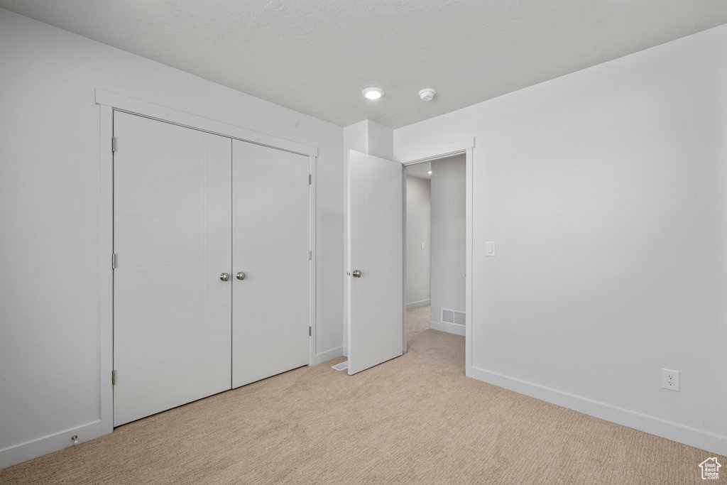 Unfurnished bedroom with carpet, baseboards, and a closet