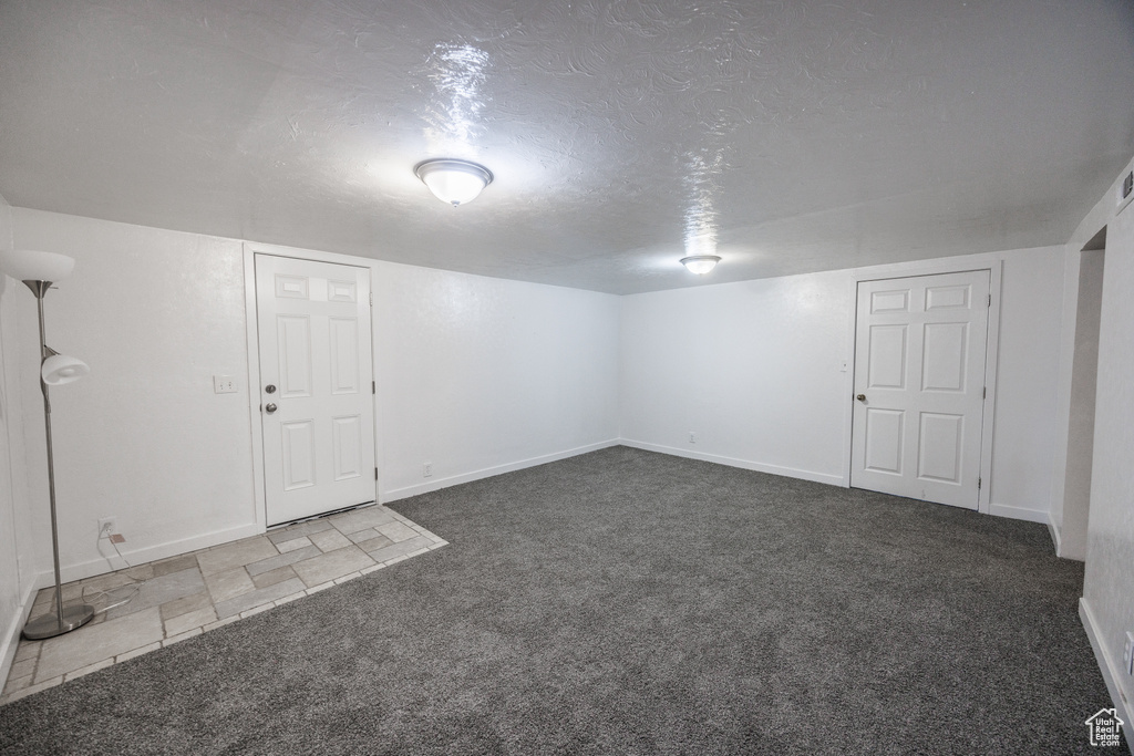 Finished basement featuring carpet, baseboards, and a textured ceiling