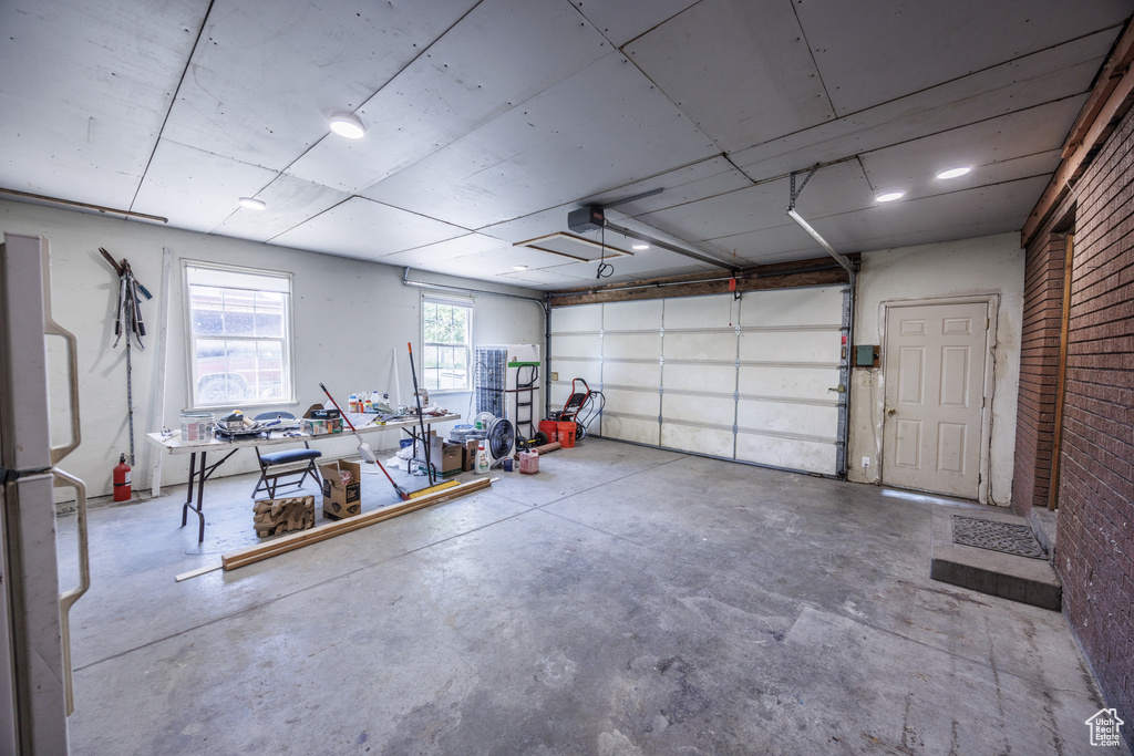 Garage featuring freestanding refrigerator and a garage door opener