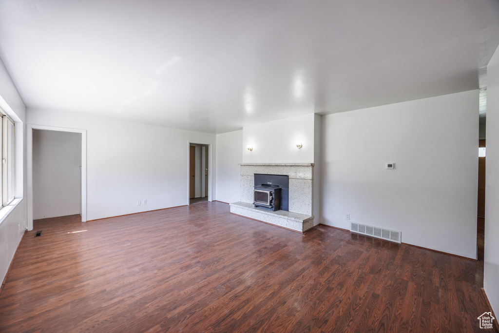 Unfurnished living room featuring dark wood-type flooring