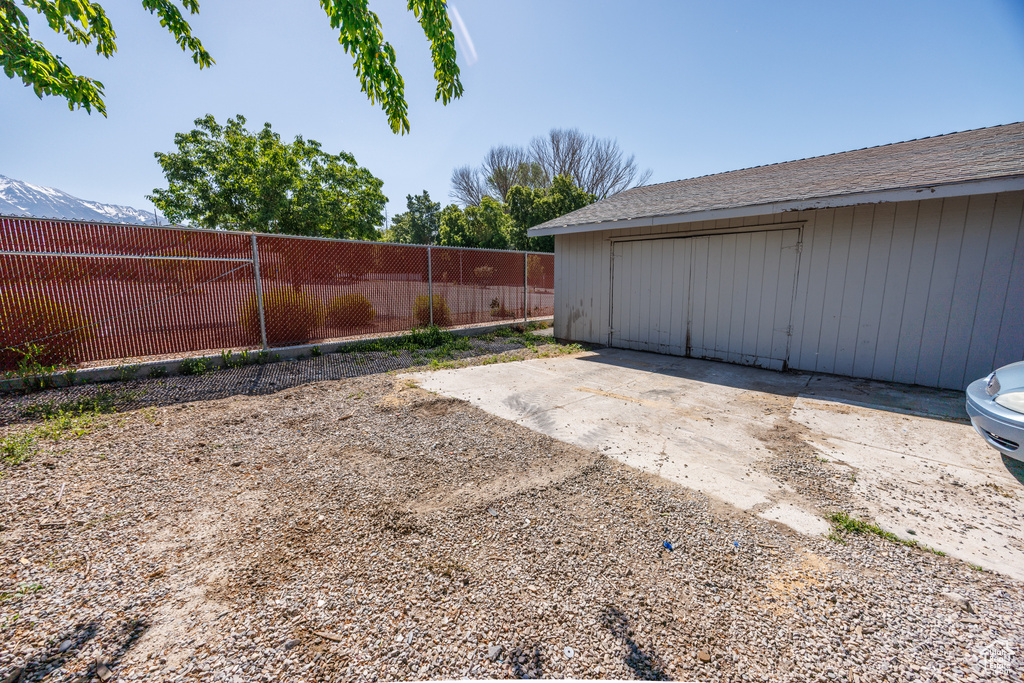 View of yard featuring a garage and an outbuilding