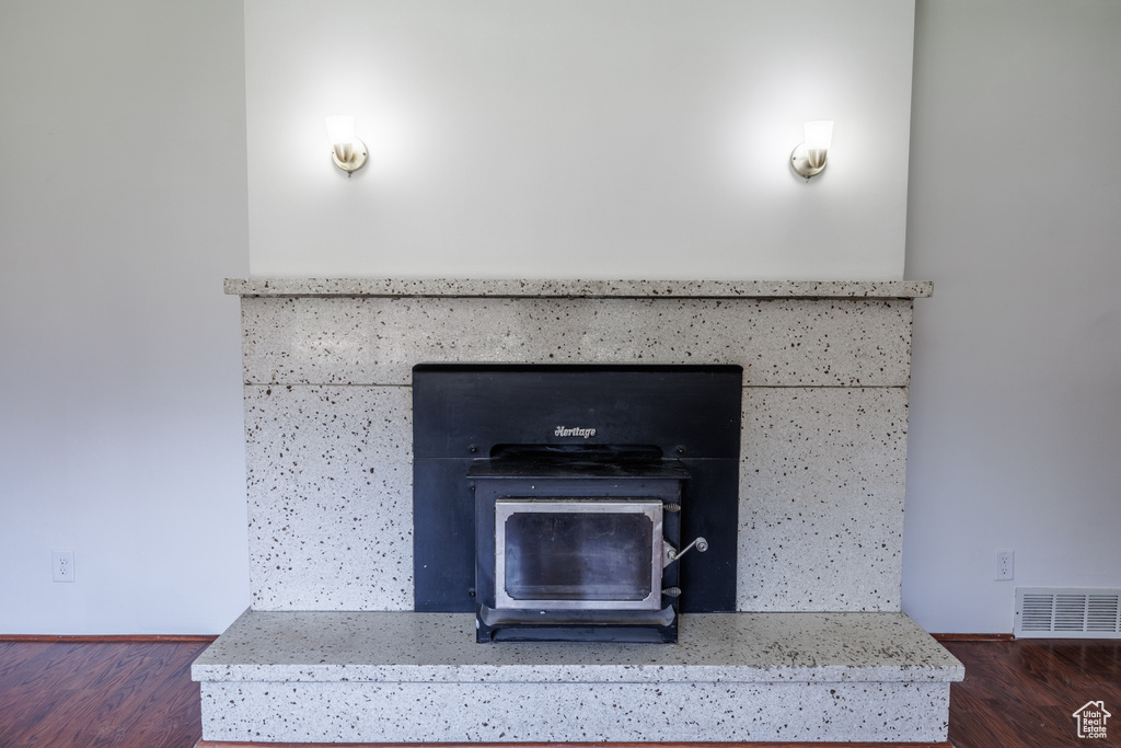 Detailed view of a wood stove, wood finished floors, and baseboards