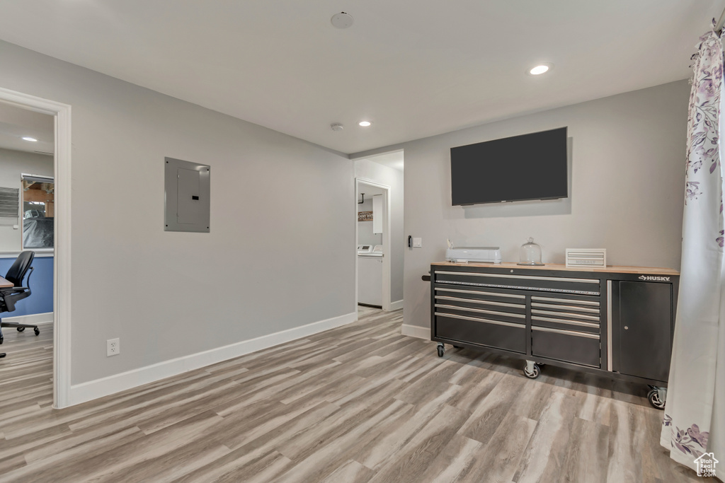 Living area featuring electric panel, light wood-style floors, recessed lighting, baseboards, and washer / clothes dryer