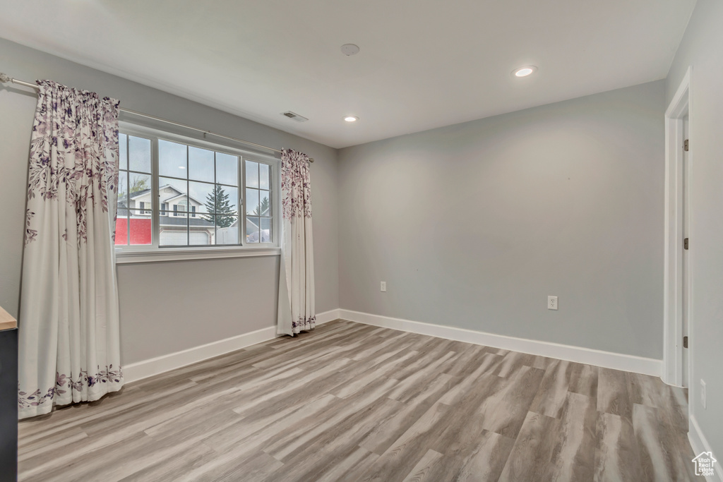 Spare room featuring baseboards, recessed lighting, and wood finished floors
