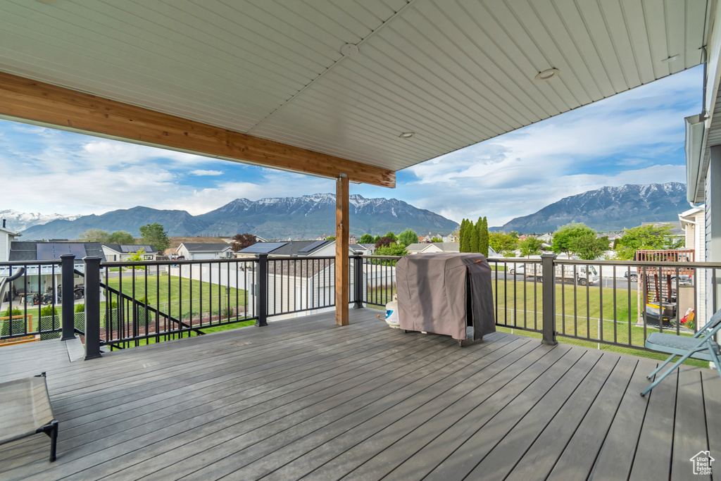 Deck with a mountain view and a lawn