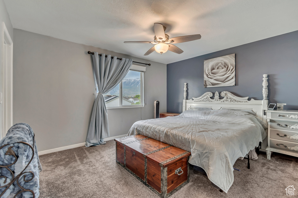 Carpeted bedroom featuring ceiling fan and baseboards