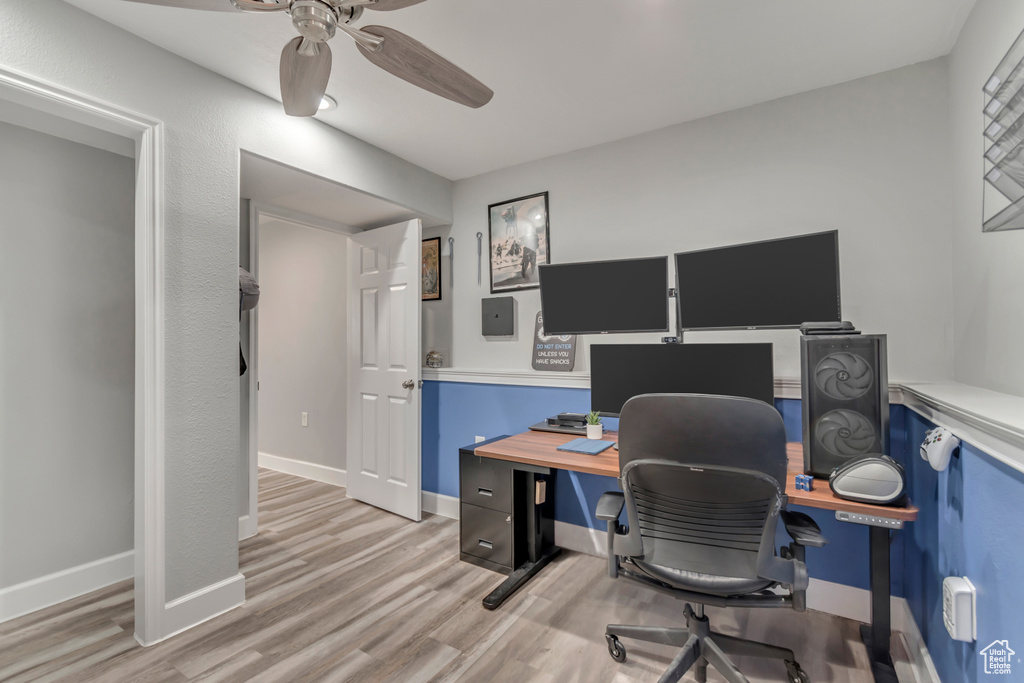 Office area featuring light wood-style flooring, a ceiling fan, and baseboards