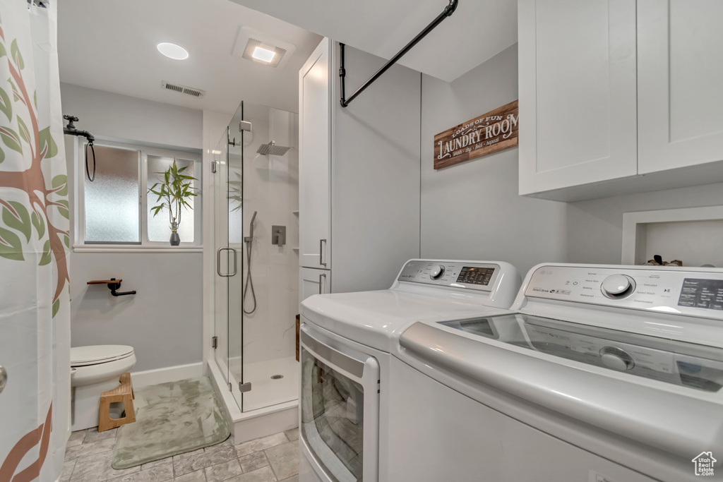 Laundry room featuring washer and clothes dryer and baseboards