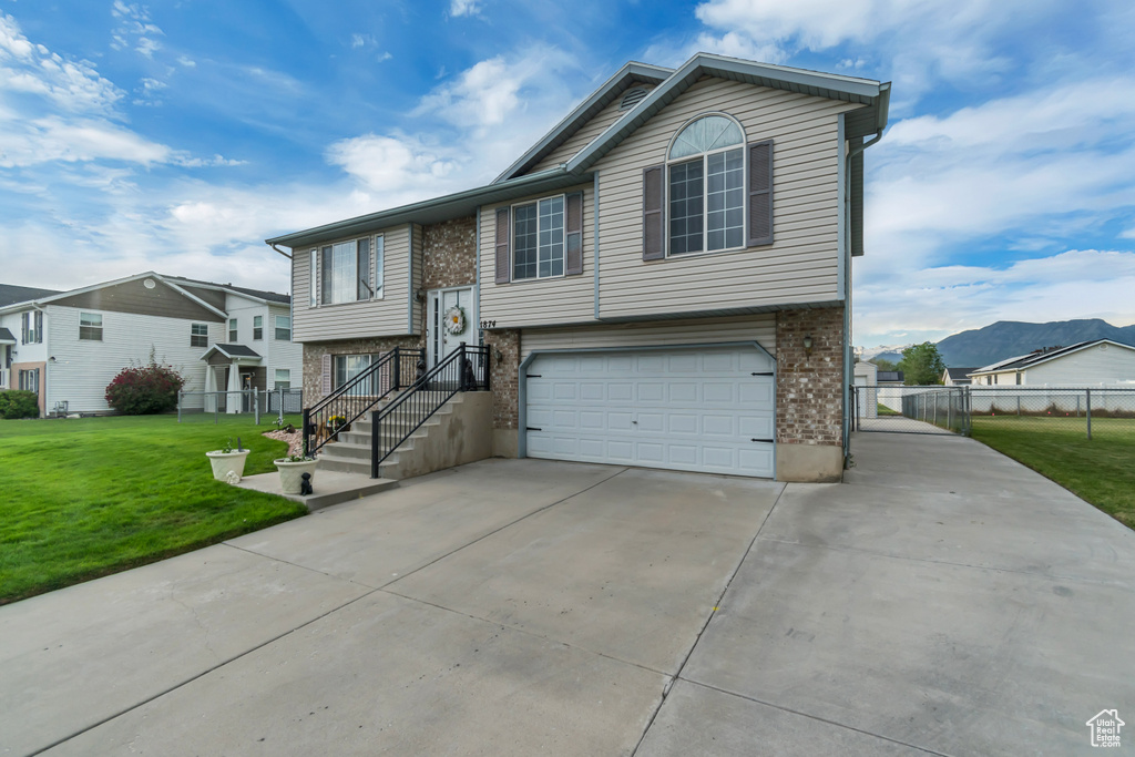 View of front facade featuring driveway, an attached garage, brick siding, and a residential view