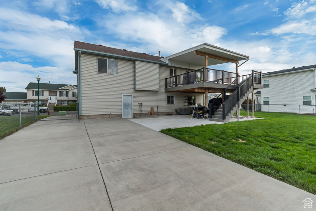 Back of house with a wooden deck, a patio, and stairs