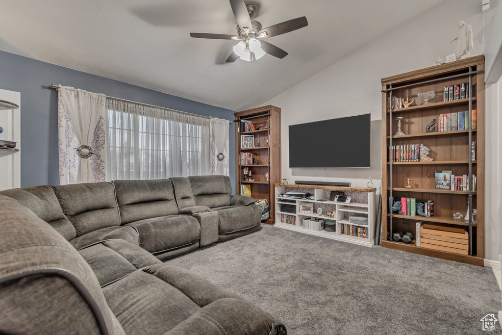 Carpeted living room featuring vaulted ceiling and a ceiling fan