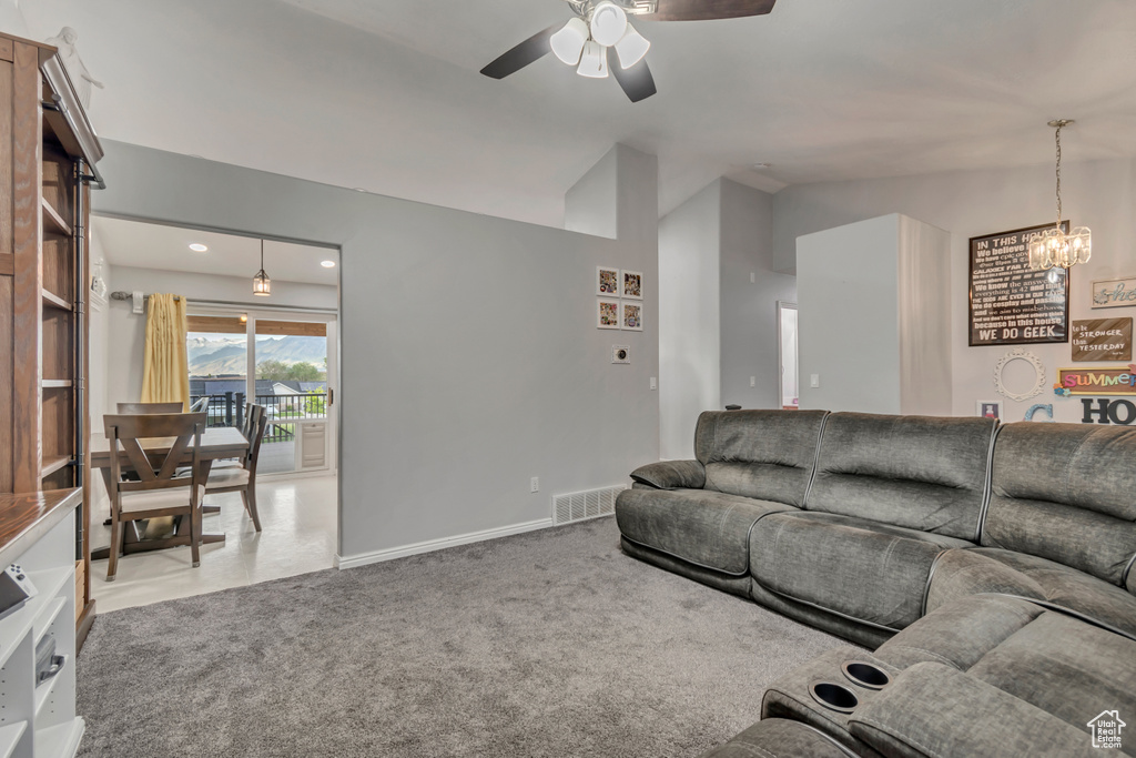 Living room featuring lofted ceiling, a ceiling fan, and a chandelier