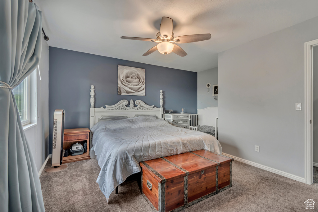 Bedroom with carpet flooring, baseboards, ceiling fan, and radiator heating unit