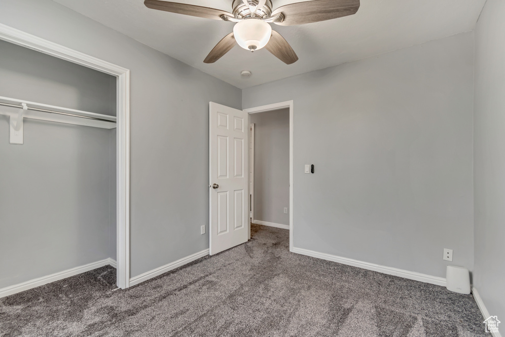 Unfurnished bedroom featuring carpet floors, a closet, baseboards, and a ceiling fan