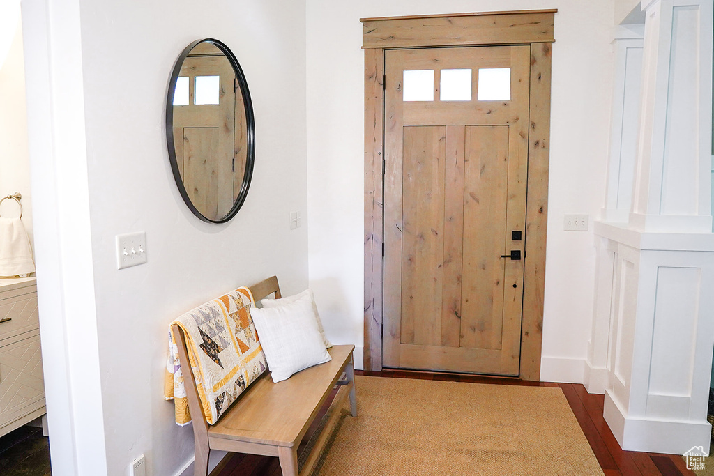 Foyer entrance with dark wood-style flooring and baseboards