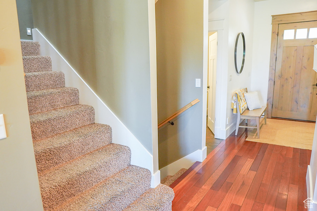 Entrance foyer with hardwood / wood-style flooring, stairway, and baseboards