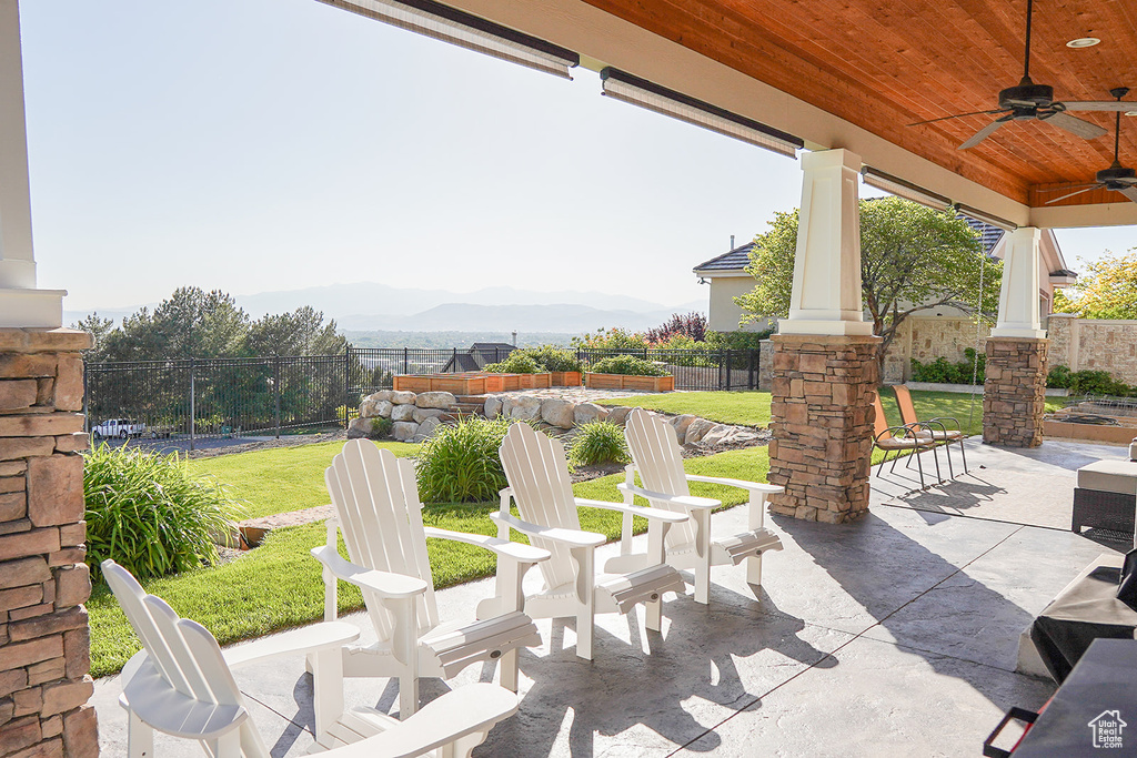View of patio / terrace featuring a ceiling fan and a mountain view
