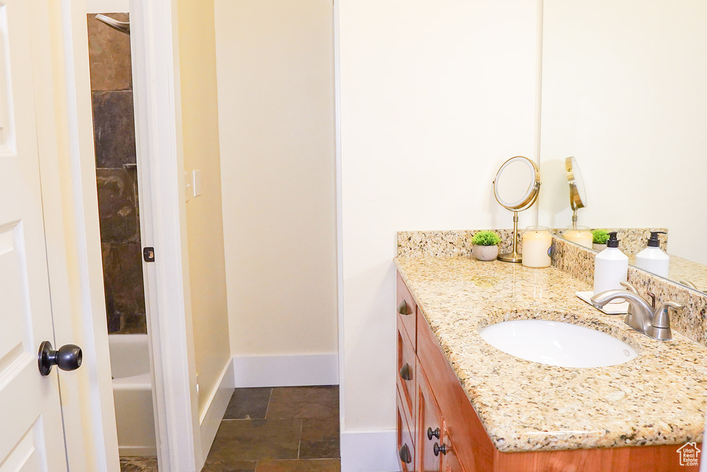 Full bath with vanity and baseboards