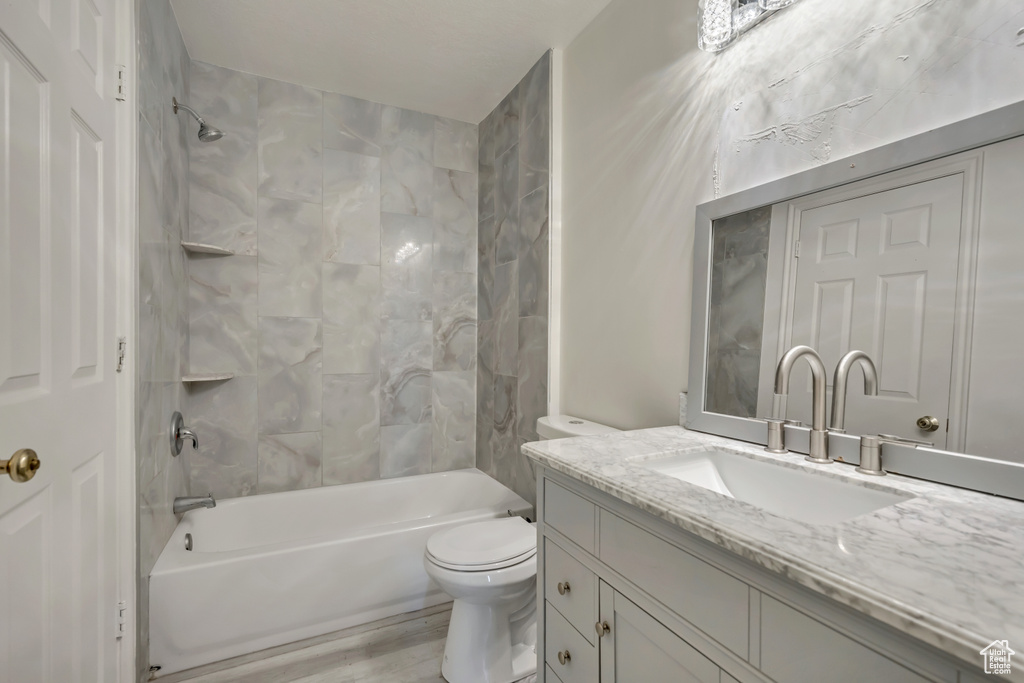 Bathroom featuring vanity,  shower combination, toilet, and wood finished floors