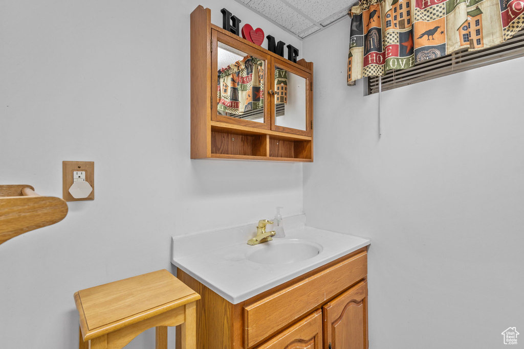 Bathroom featuring a paneled ceiling and vanity