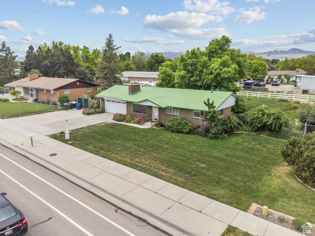 Ranch-style home with concrete driveway, brick siding, a garage, and a mountain view