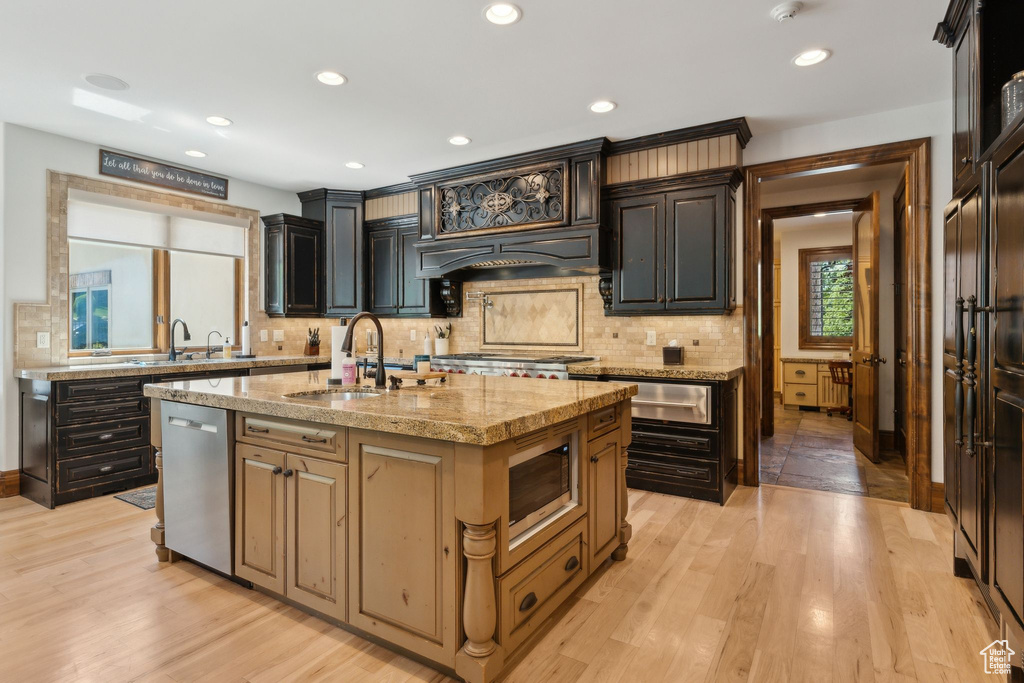 Kitchen with stainless steel appliances, a sink, a warming drawer, tasteful backsplash, and recessed lighting