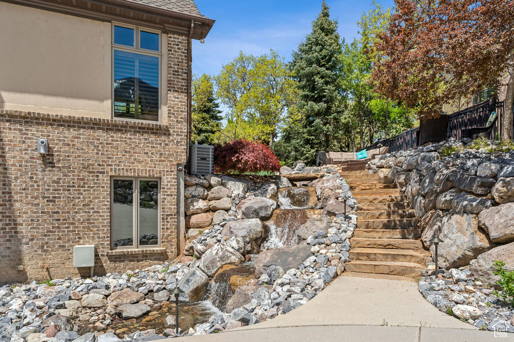 View of property exterior featuring brick siding and stairway