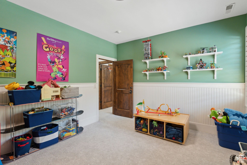 Playroom featuring a wainscoted wall and carpet flooring