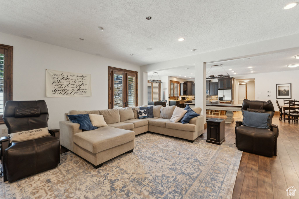 Living area featuring recessed lighting, light wood-style floors, plenty of natural light, and a textured ceiling