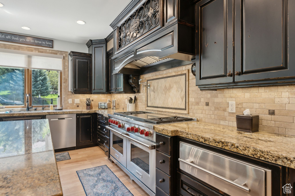Kitchen featuring appliances with stainless steel finishes, a sink, a warming drawer, decorative backsplash, and recessed lighting