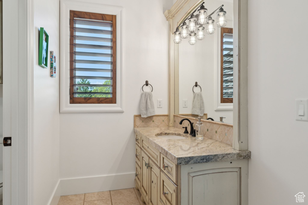 Bathroom with vanity, tile patterned floors, and baseboards