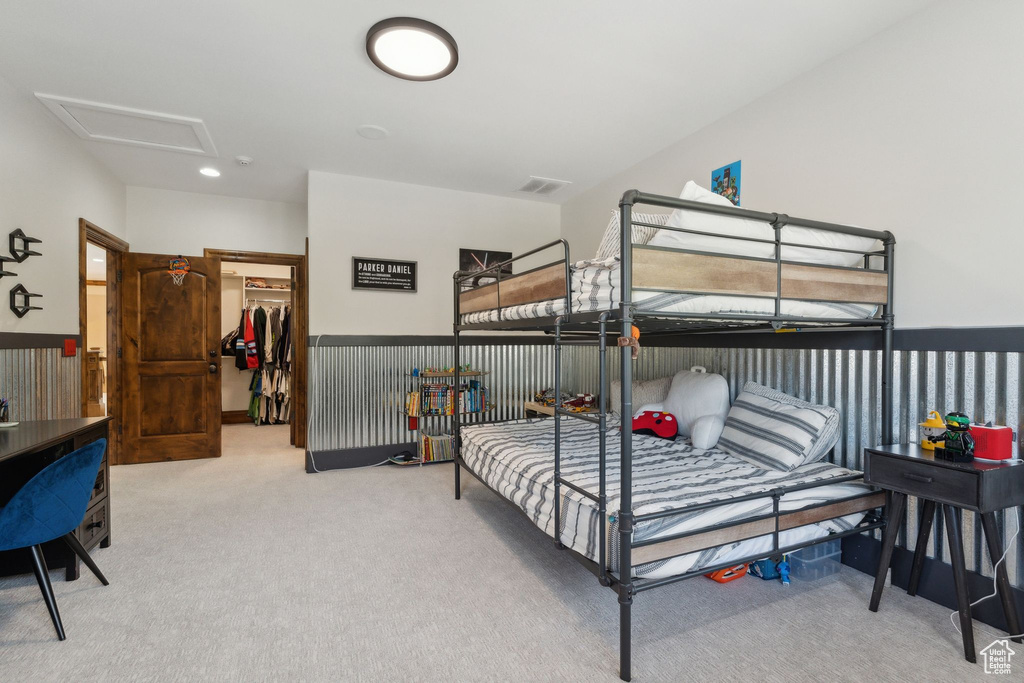 Bedroom with carpet, a walk in closet, a closet, and attic access