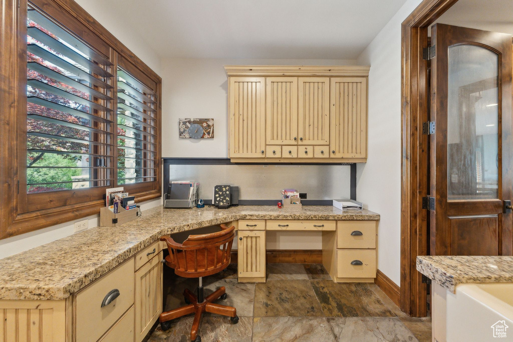 Home office with built in study area and stone finish flooring