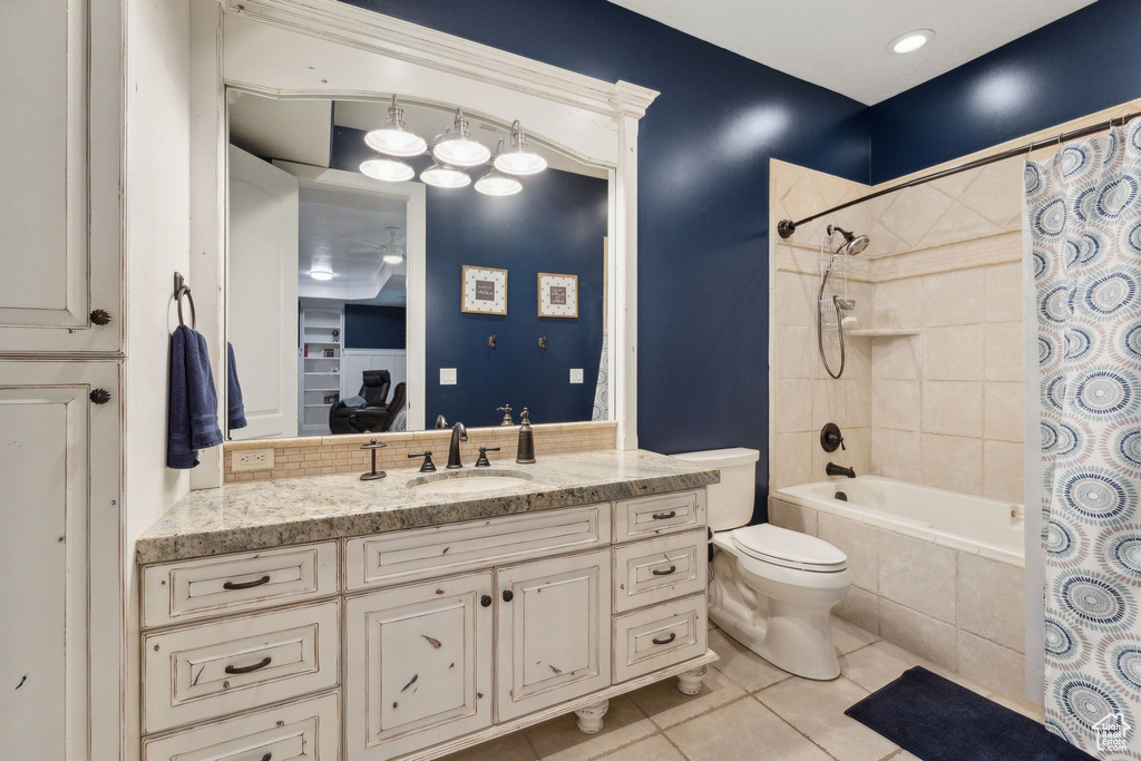 Full bath with tile patterned floors, tiled shower / bath combo, vanity, and toilet