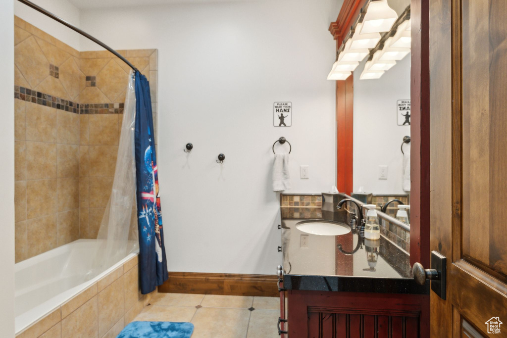 Full bathroom with tile patterned floors, tiled shower / bath, vanity, and baseboards